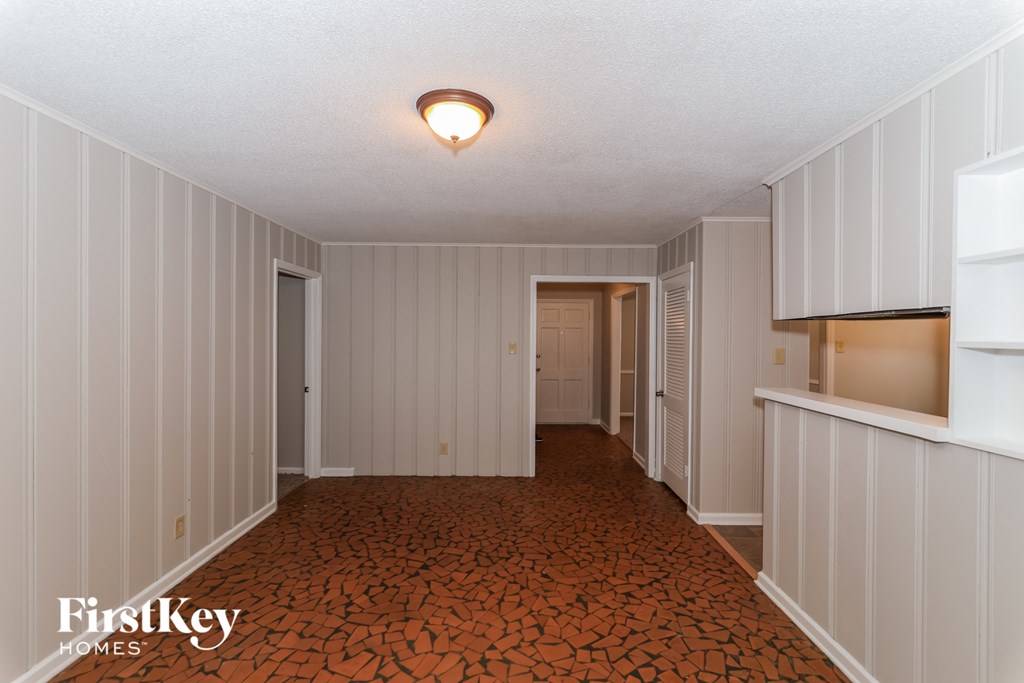 A long hallway with a light on the ceiling and a patterned floor.