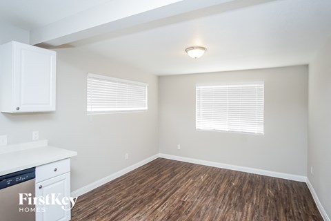A kitchen area with a dishwasher and wooden flooring.