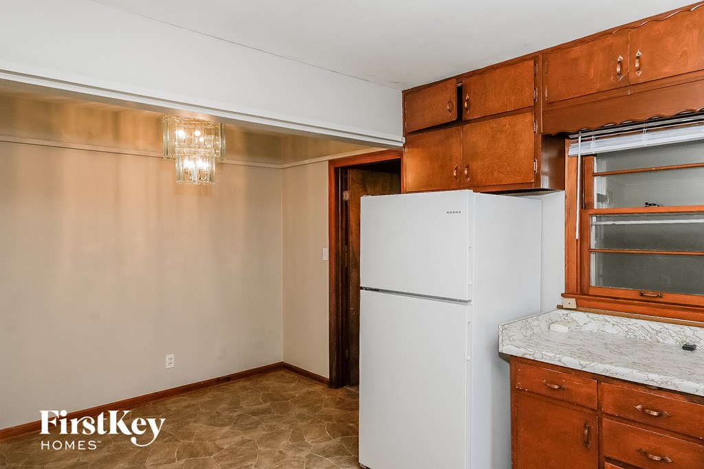 A kitchen with a white fridge and wooden cabinets.