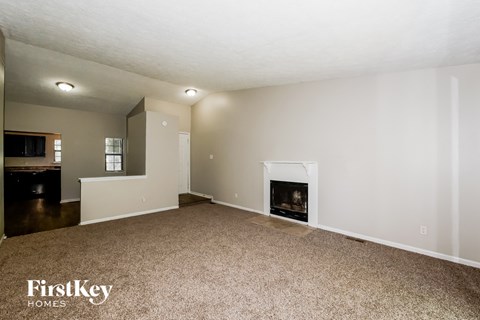 A living room with a fireplace and a carpet.