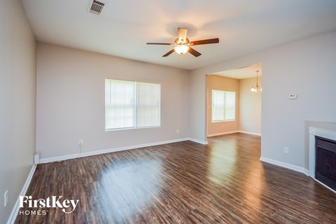 the living room with wood floors and a ceiling fan