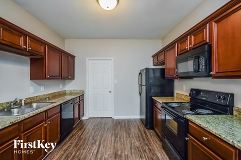 a kitchen with wood flooring and black appliances