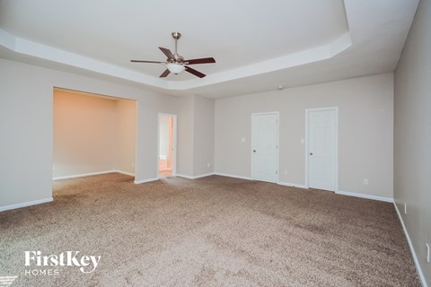 a living room with carpet and a ceiling fan