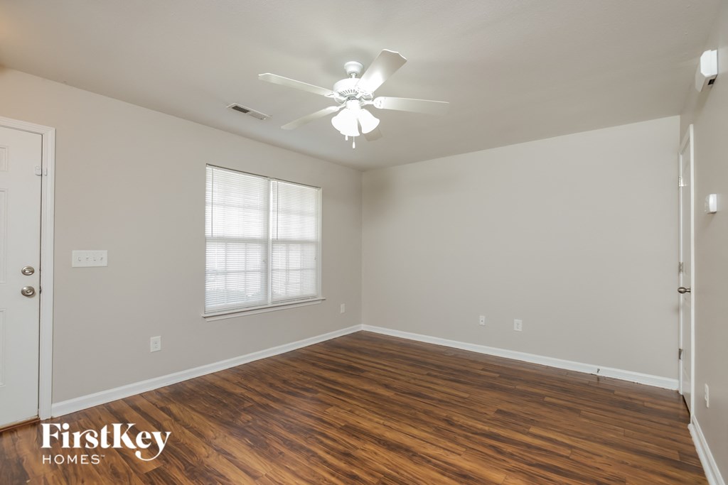 a bedroom with a ceiling fan and wood flooring