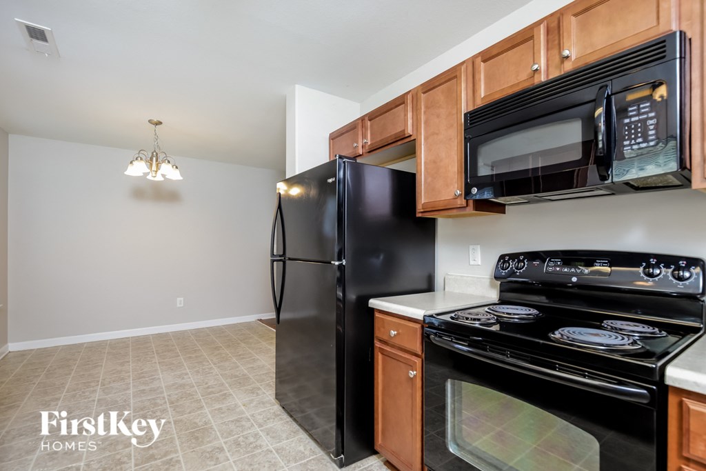 a kitchen with black appliances and wood cabinets
