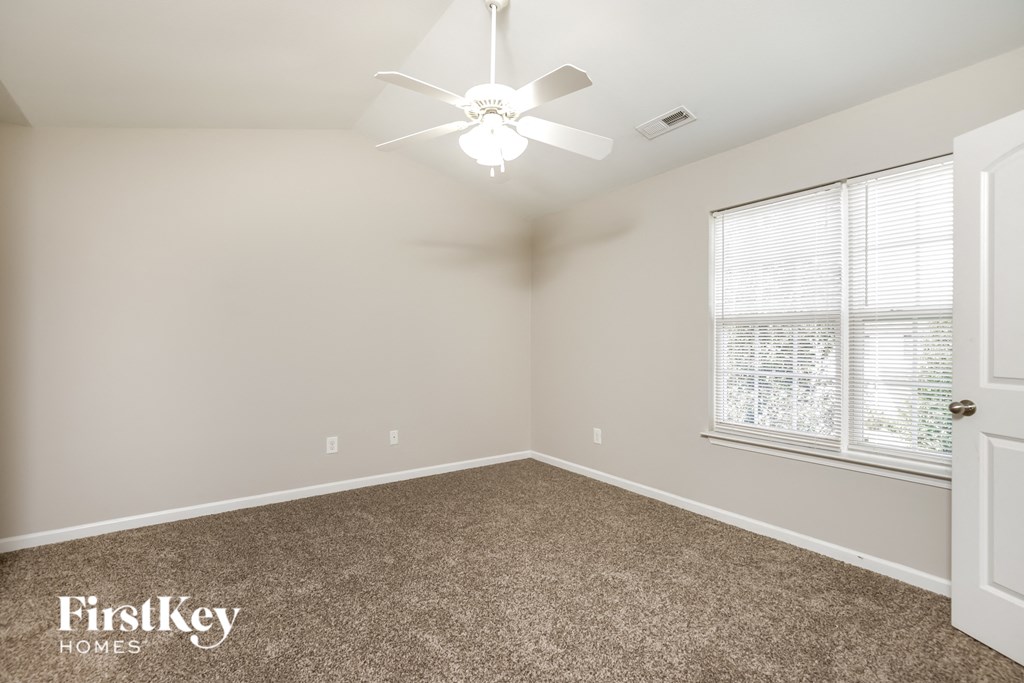 a bedroom with a ceiling fan and a window