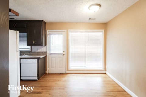 a small kitchen with a window and a white stove and refrigerator
