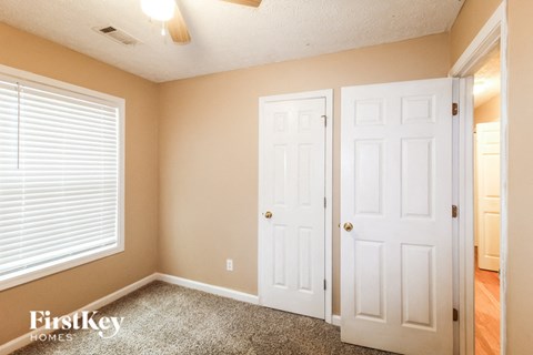 a bedroom with two closets and a window and a door