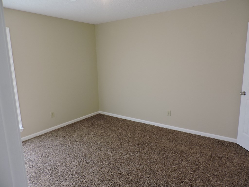 an empty room with carpet and a door