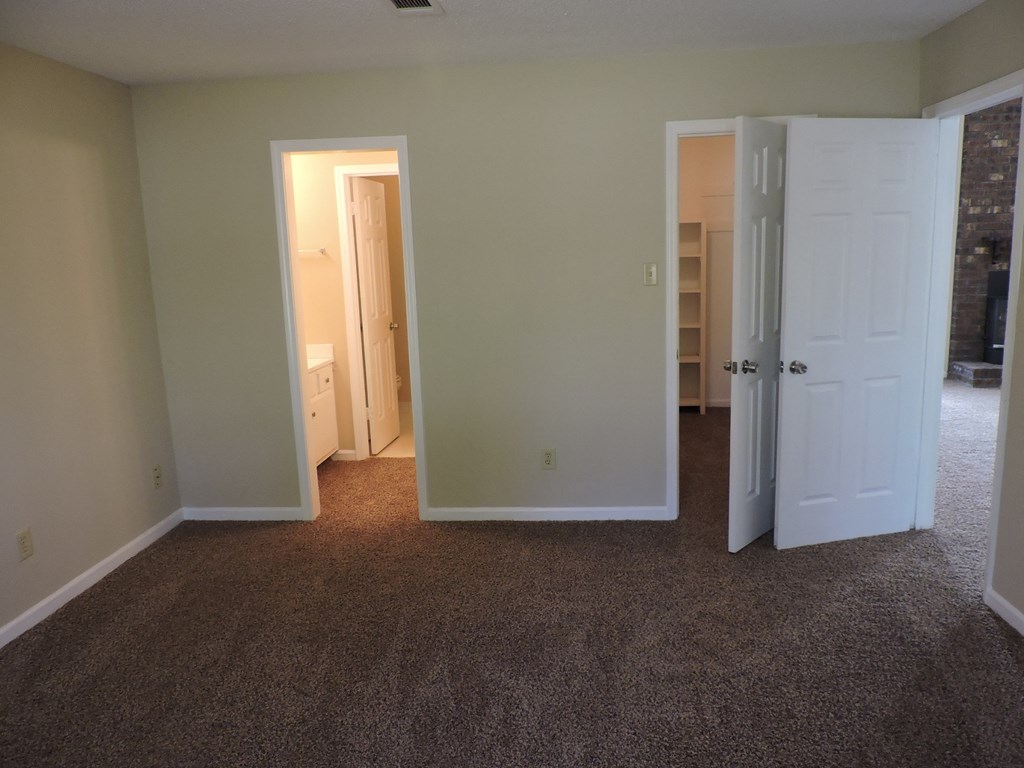 an empty room with a carpeted floor and two doors