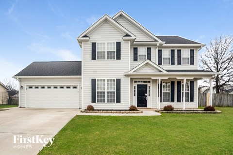 a white house with black shutters and a lawn