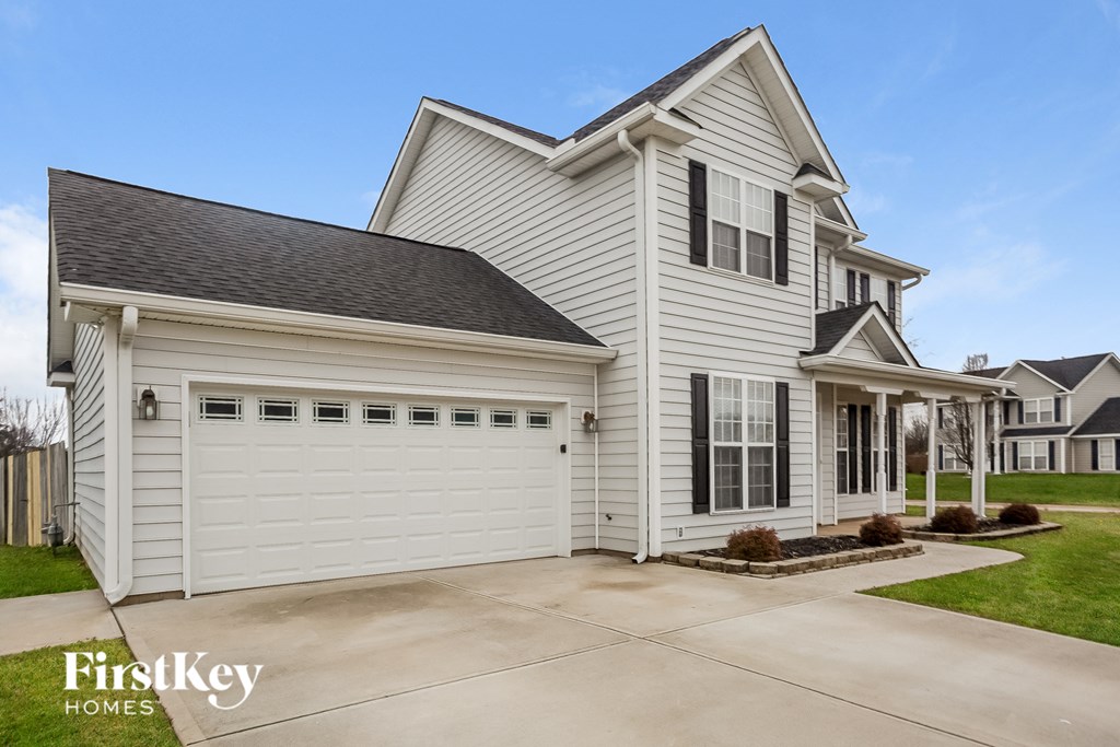 a white house with a white garage door and a driveway