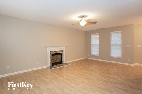 the living room with wood floors and a fireplace