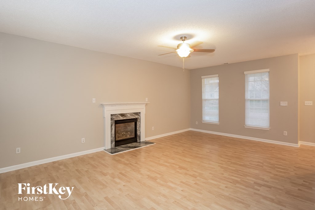 the living room with wood floors and a fireplace