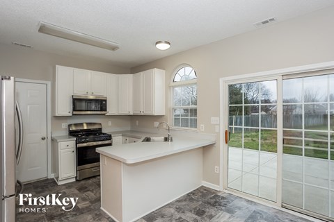 a kitchen with white cabinets and a sink and a window