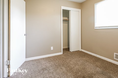 a bedroom with a carpeted floor and a door to a closet