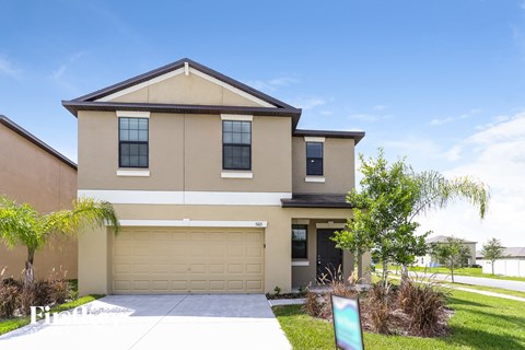 A two-story house with a garage and a driveway.