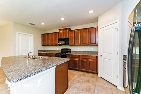 A kitchen with brown cabinets and a granite countertop.