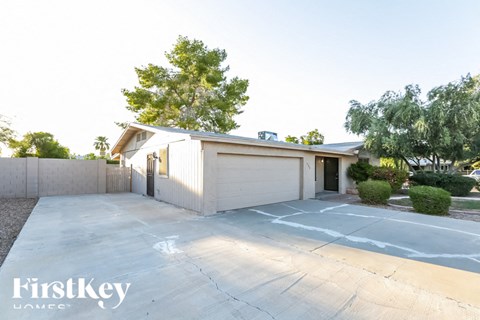 A house with a garage and a driveway in front of it.