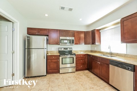 A kitchen with brown cabinets and a stainless steel refrigerator.