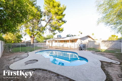 A Firstkey Home pool surrounded by a white fence.