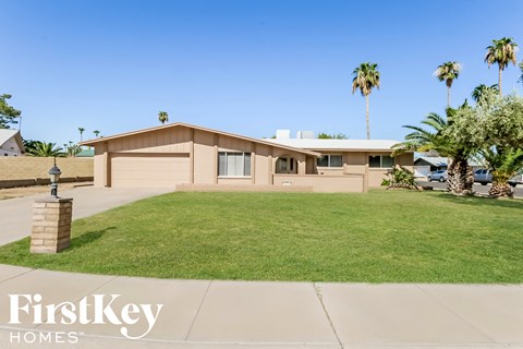 a house with a lawn and palm trees