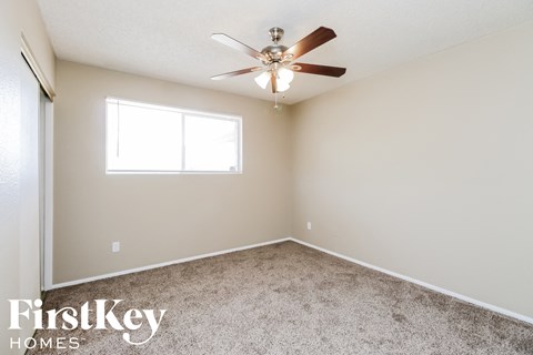 a bedroom with carpet and a ceiling fan