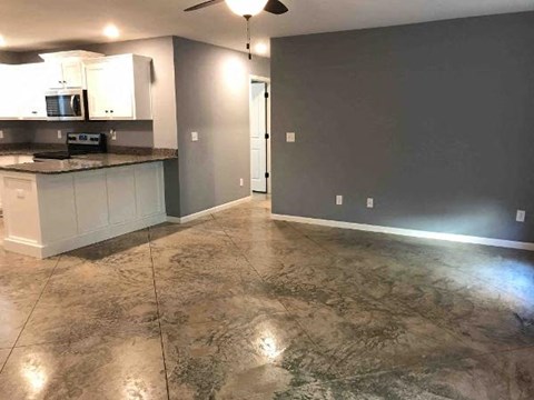 A kitchen with a marble floor and white cabinets.