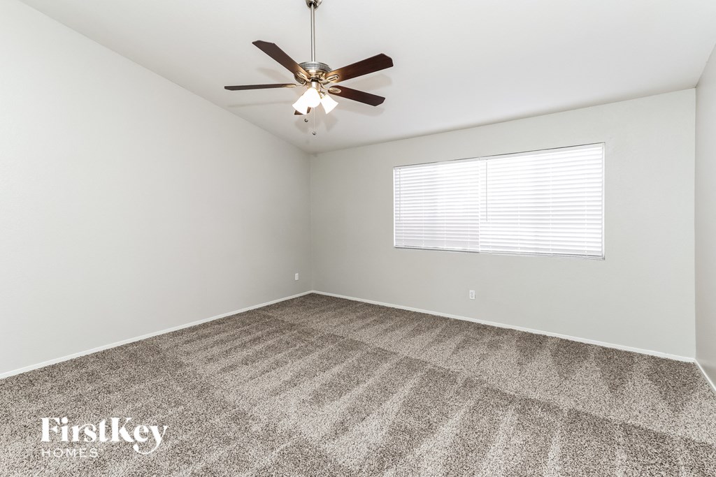 a living room with carpet and a ceiling fan