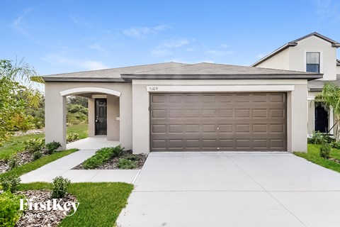 a home with a garage door and a driveway