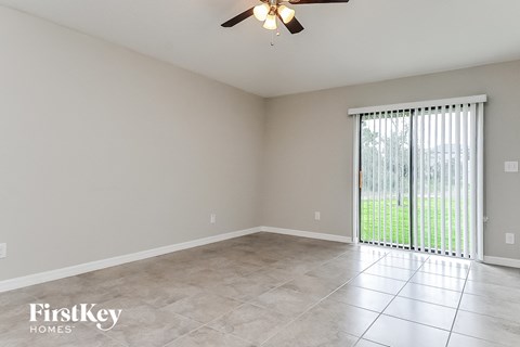 a living room with a large window and a ceiling fan