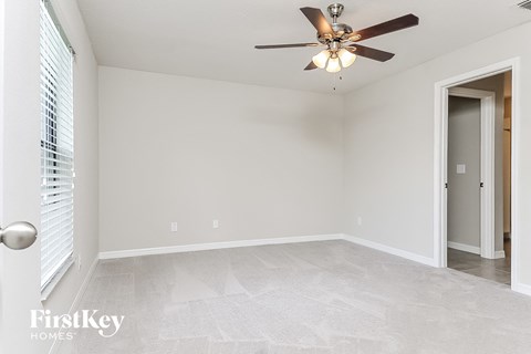 a bedroom with a ceiling fan and a door to a closet