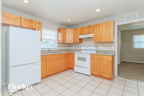 A kitchen with wooden cabinets and a white refrigerator.