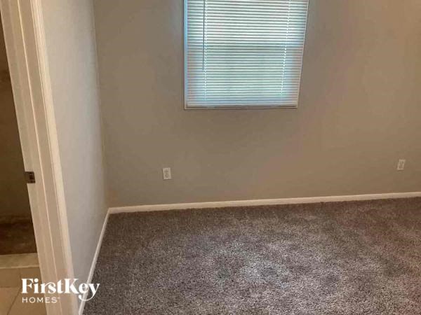 a empty room with a window and a carpeted floor
