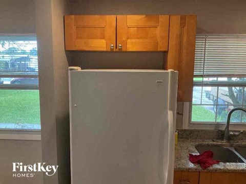 a white refrigerator in a kitchen next to a sink