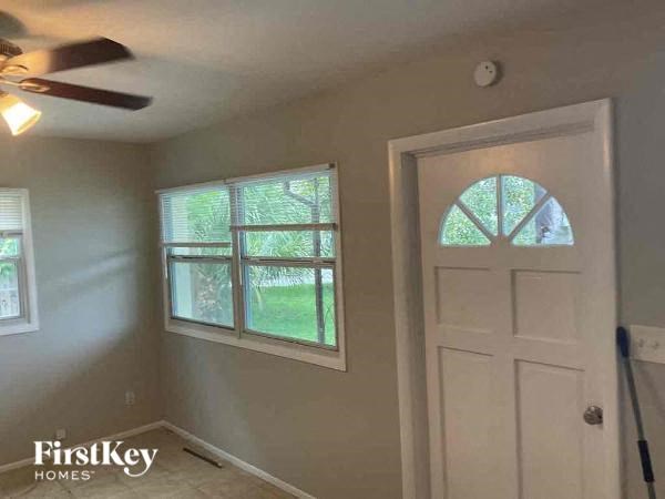 an empty room with a white door and a window