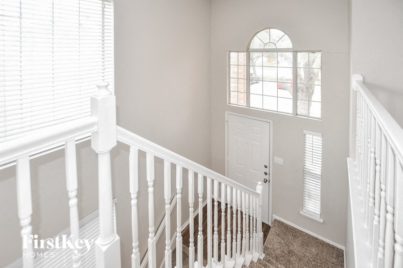 A white staircase with a carpeted floor and a white door.