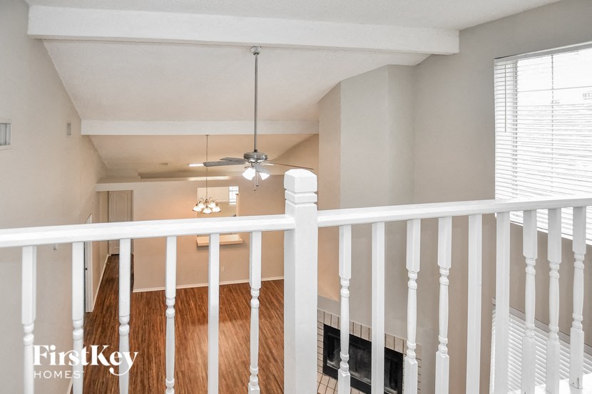 A white balcony with a light hanging from the ceiling.