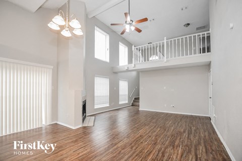 A spacious room with wooden floors and a balcony.