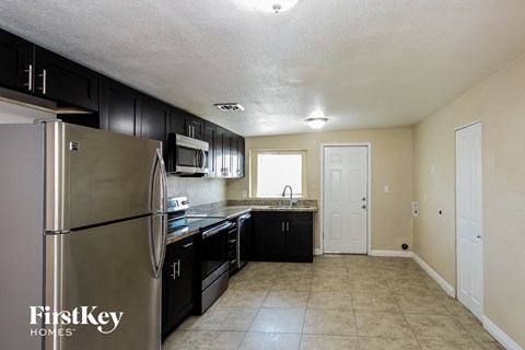 A kitchen with a refrigerator, microwave, and sink.