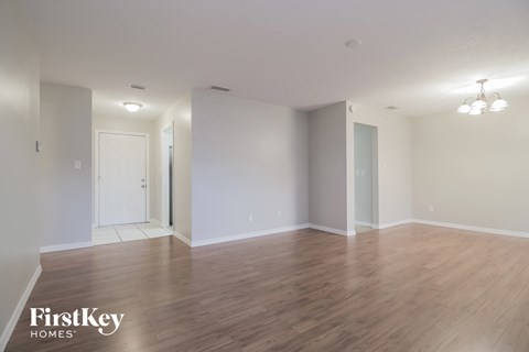 an empty living room with wood flooring and white walls