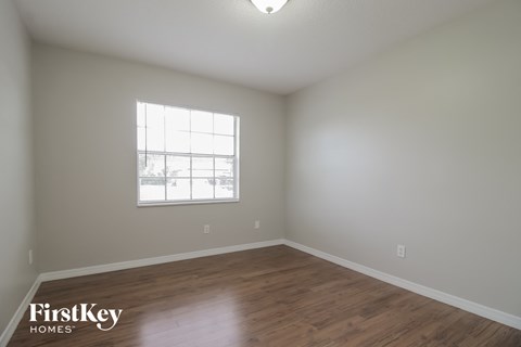 a living room with wood floors and a window