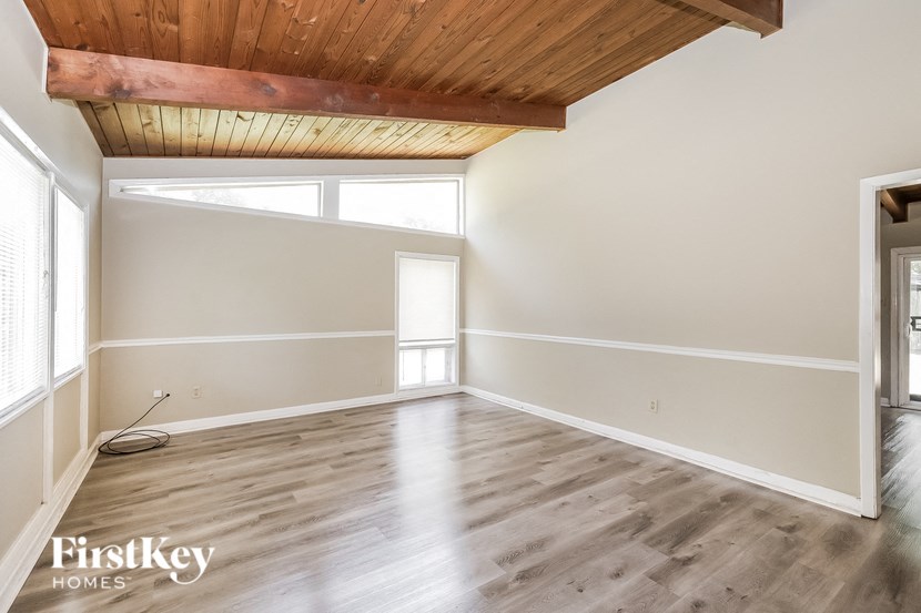 an empty living room with wood floors and white walls