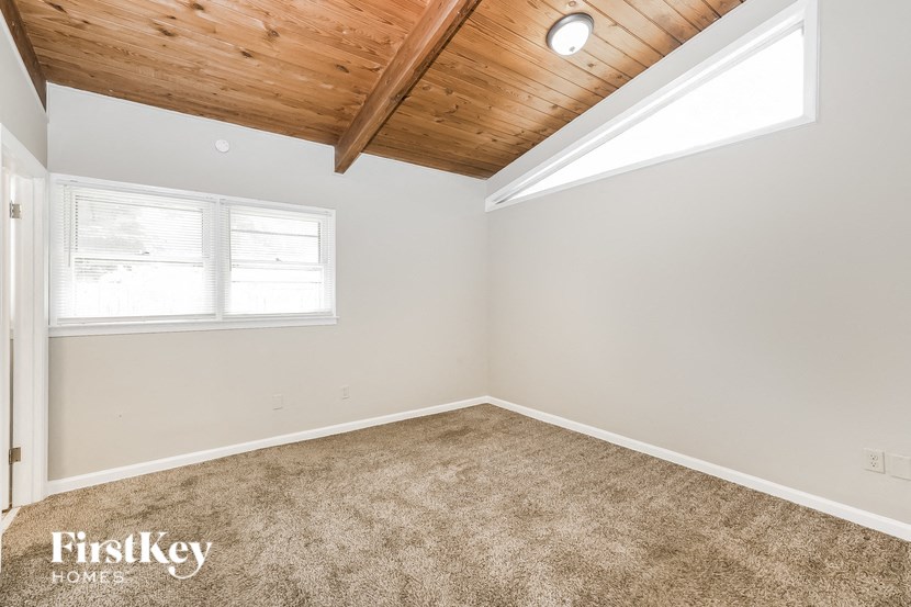 the living room of a home with carpet and a window