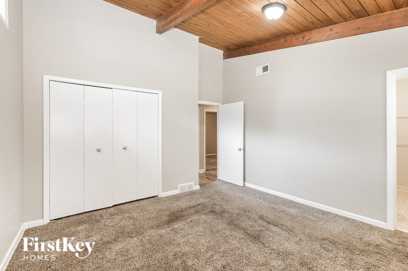 the master bedroom has carpeted floors and white closets