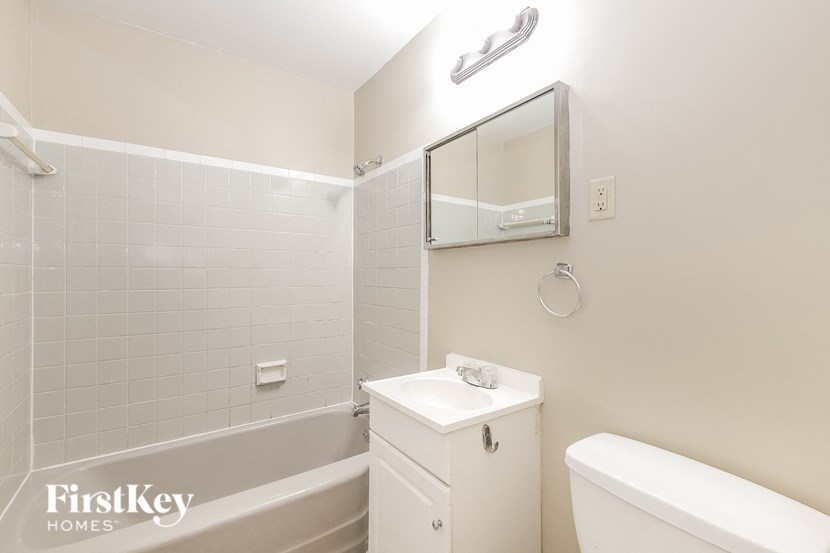 a white bathroom with a sink toilet and bath tub