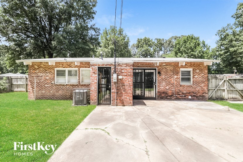 a small brick building with two doors and a driveway