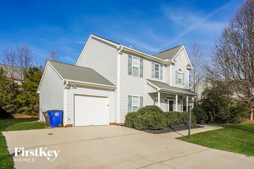 a white house with a white garage with a driveway