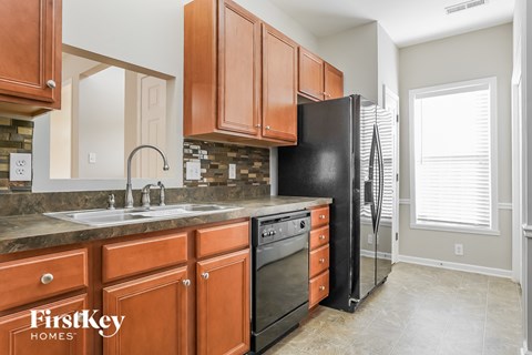 a kitchen with wooden cabinets and a black refrigerator