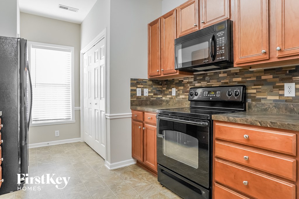 a kitchen with black appliances and wooden cabinets